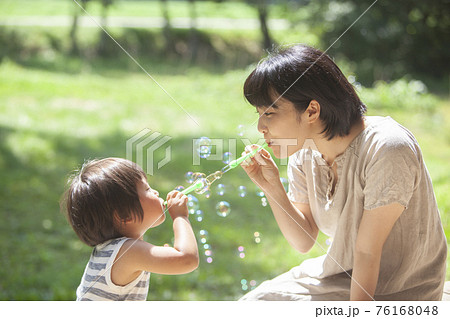 夏の庭でシャボン玉で遊ぶ親子の写真素材 [76168048] - PIXTA
