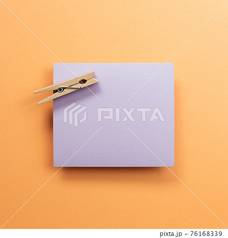Purple memo pad with wooden clip on orange background. top view, copy space Purple memo pad with wooden clip on orange background. top view, copy space 76168339