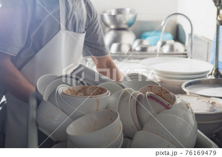 Man washing dish in sink Man washing dish in sink 76169479