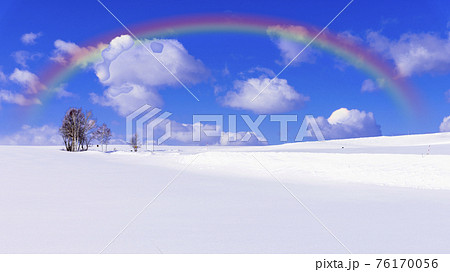 厳冬期の白い雪原にかかる虹 76170056