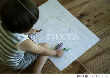 フローリングの床で お絵描きをする子供 の写真素材