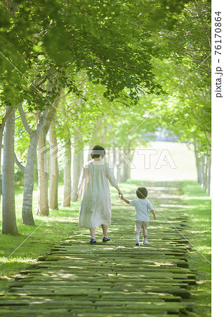 緑のトンネルを歩いていく親子 76170864