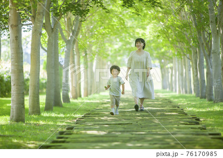 公園を散歩する親子 76170985