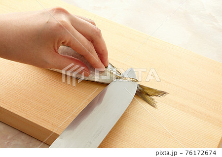 包丁で鯵をさばいている手元 76172674
