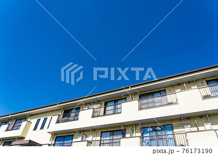 青空に映える南向きのアパートの写真素材