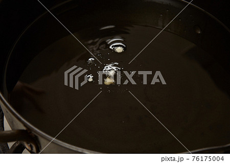 油の温度を測るために鍋に入れられた揚げ衣 76175004
