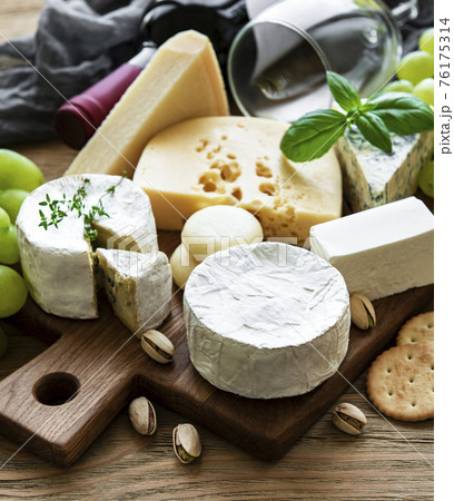 Various types of cheese, grapes and wine 76175314