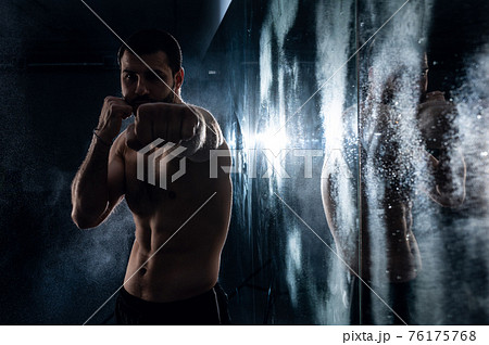 boxer training in the gym with reflection in low key photo for fight club advertisement boxer training in the gym with reflection in low key photo for fight club advertisement 76175768