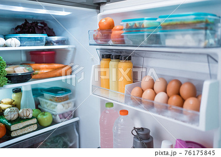 open fridge door with full of food and ingredient 76175845