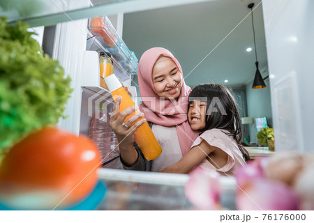 muslim asian mother and her daughter having snack time together 76176000