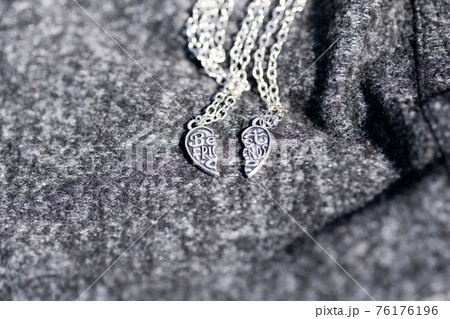 Set of best friends heart made up of two parts necklace shoot outside in a summer day closeup. Selective Focus Set of best friends heart made up of two parts necklace shoot outside in a summer day closeup. Selective Focus 76176196