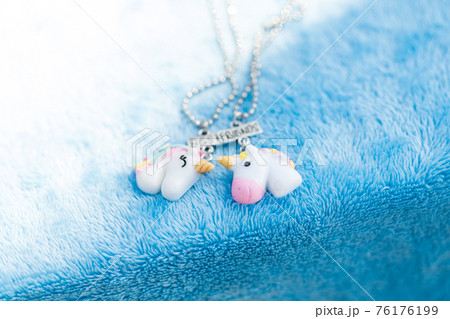 Pendant set of best friends two unicorns necklace shoot outside in a summer day closeup. Selective Focus Pendant set of best friends two unicorns necklace shoot outside in a summer day closeup. Selective Focus 76176199