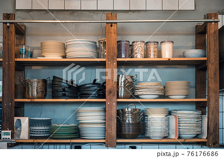 Kitchenware with dishware on kitchen wooden shelving 76176686