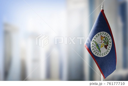 A small flag of Belize on the background of a blurred background A small flag of Belize on the background of a blurred background 76177710