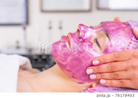 Cosmetologist making massage the skin of the forehead. Woman in a spa salon on cosmetic procedures for facial care. Beautician applies a woman a therapeutic cream on her face. . Cosmetologist making massage the skin of the forehead. Woman in a spa salon on cosmetic procedures for facial care. Beautician applies a woman a therapeutic cream on her face. . 76178403