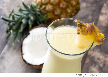 Pina colada cocktail in glass on wood Pina colada cocktail in glass on wood 76178598
