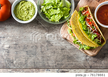 Traditional Mexican tacos with meat and vegetables on wood Traditional Mexican tacos with meat and vegetables on wood 76178661
