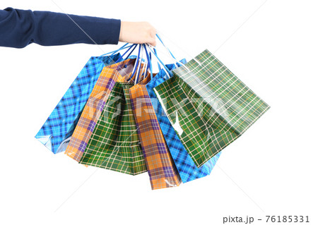 Child hand holding paper shopping bags isolated on white background. Child hand holding paper shopping bags isolated on white background. 76185331