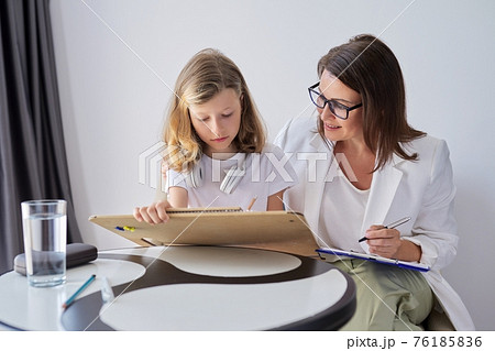 Professional family psychologist helping child, teacher social worker talking to a girl Professional family psychologist helping child, teacher social worker talking to a girl 76185836