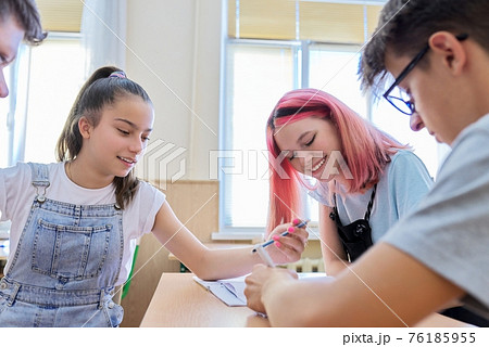 Group of teenage students in the classroom sitting at their desks Group of teenage students in the classroom sitting at their desks 76185955