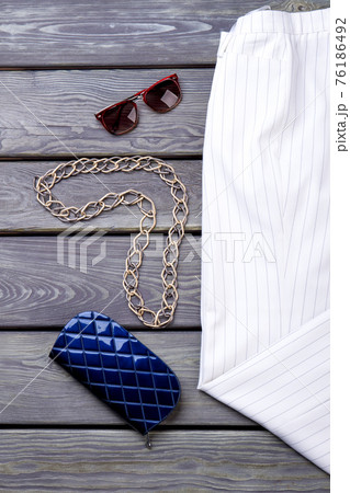 Chain necklace with sunglasses and blue wallet. 76186492