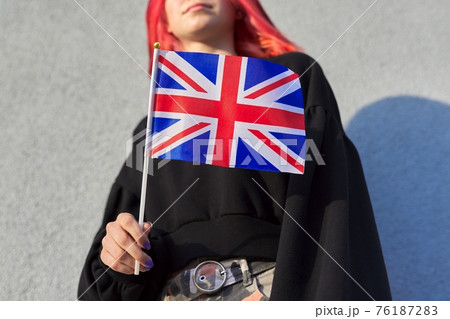 Female student teenager with British flag, gray outdoor wall background 76187283
