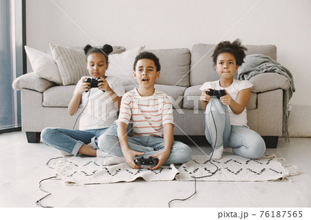 Children play in video games at home on floor Children play in video games at home on floor 76187565