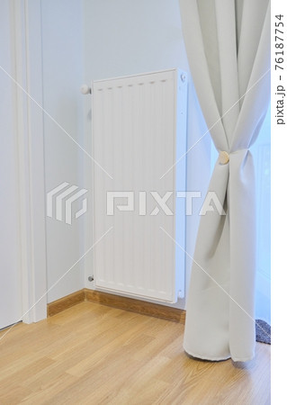 White heating radiator with temperature thermostat in interior of apartment White heating radiator with temperature thermostat in interior of apartment 76187754