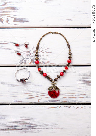 Vertical photo of necklace with amulet, bracelet, earrings. 76188075
