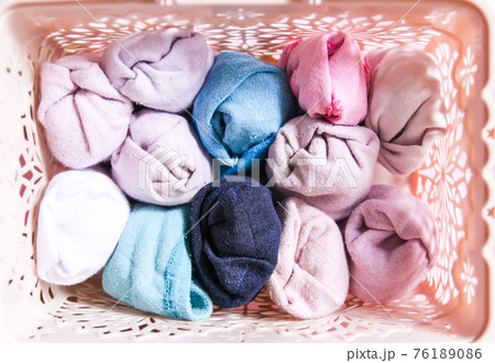 Clothes vertical storage in home wardrobe. Items of clothing in a box on soft pink background. 76189086