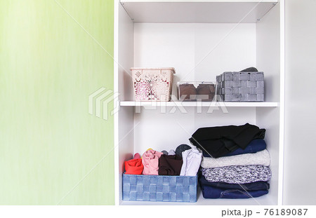 Different clothes in home wardrobe. Small space organization. Vertical storage. Different clothes in home wardrobe. Small space organization. Vertical storage. 76189087