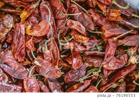 Dried red chilis in a pile ready for sale 76190553