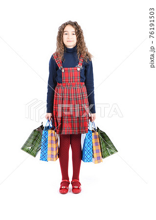 Child with a packaging checkered texture isolated on white background. Girl likes shopping on sale season. Holiday present, shopping. Child with a packaging checkered texture isolated on white background. Girl likes shopping on sale season. Holiday present, shopping. 76191503