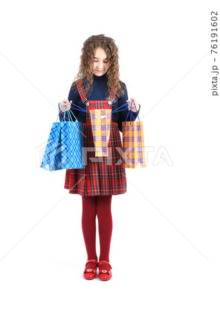 Child with a packaging checkered texture isolated on white background. Girl likes shopping on sale season. Holiday present, shopping. Child with a packaging checkered texture isolated on white background. Girl likes shopping on sale season. Holiday present, shopping. 76191602