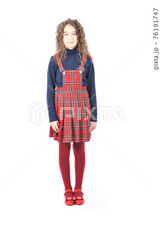 Portrait of adorable smiling schoolgirl with curl hair standing isolated on a white 76191747
