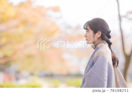 秋の公園で黄昏れる女性 秋の公園で黄昏れる女性 76198251