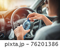 Women drink water during driving in the morning. 76201386