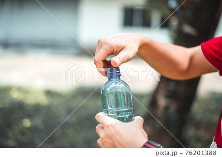 Man opening bottle of water Man opening bottle of water 76201388