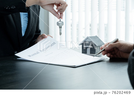 Real estate agent broker hand over the house key to the new owner after completing the signing according to agreement renting a house and buy house insurance officially completed 76202469