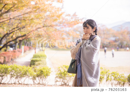 寒そうにする女性 76203163