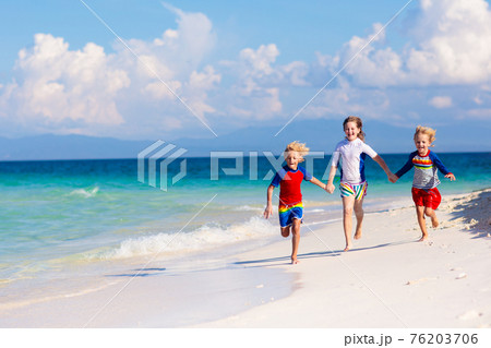 Kids playing on beach. Children play at sea. 76203706