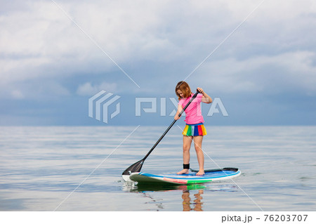 Child on stand up paddle. Water and beach sport 76203707
