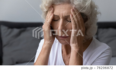 Stressed frustrated elderly woman feeling strong painful headache Stressed frustrated elderly woman feeling strong painful headache 76206872