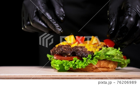 Craft burger is cooking. Consist: red sauce salsa, lettuce, red onion, pickle, cheese, chilli green pepper, air bun and marbled meat beef. Craft burger is cooking. Consist: red sauce salsa, lettuce, red onion, pickle, cheese, chilli green pepper, air bun and marbled meat beef. 76206989