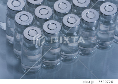 Glass medical ampoule vial for injection. Medicine is dry white drug penicillin powder or liquid with of aqueous solution in ampulla. Close up. 76207261