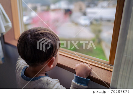 窓から外を眺める男の子 76207375