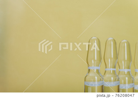 Glass medical ampoule vial for injection. Medicine is liquid sodium chloride with of aqueous solution in ampulla. Close up. Bottles ampule multicolor. Glass medical ampoule vial for injection. Medicine is liquid sodium chloride with of aqueous solution in ampulla. Close up. Bottles ampule multicolor. 76208047