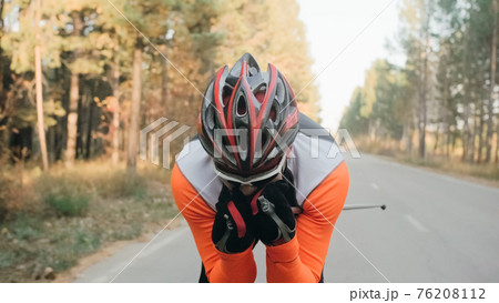 Training an athlete on the roller skaters. Biathlon ride on the roller skis with ski poles, in the helmet. Autumn workout. Roller sport. Training an athlete on the roller skaters. Biathlon ride on the roller skis with ski poles, in the helmet. Autumn workout. Roller sport. 76208112