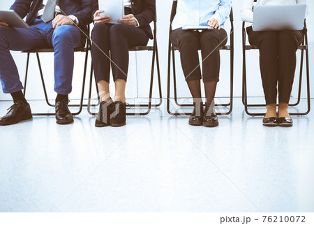 Group of business people sitting in office and waiting for job interview while using gadgets, close-up. Recruiting and headhunting concepts 76210072