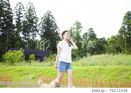 犬と散歩する女性 76211036